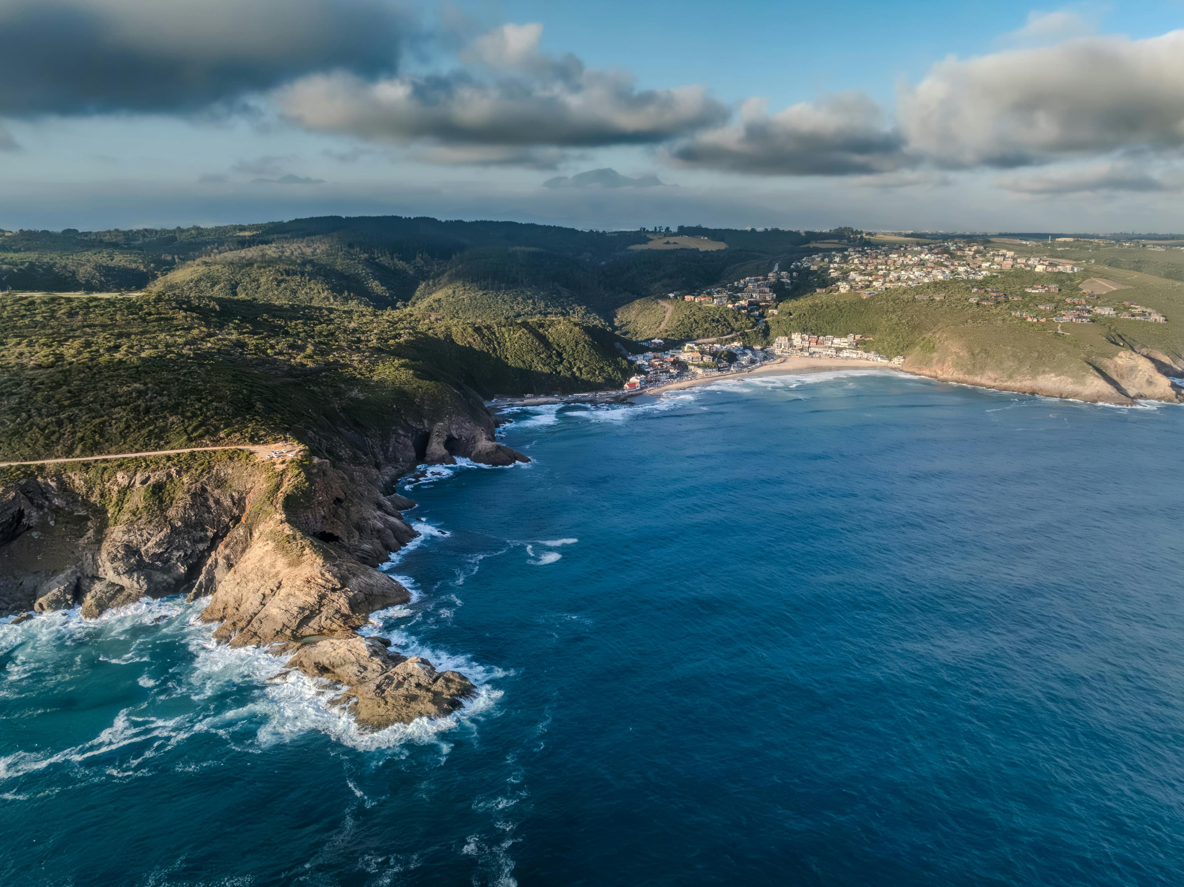A view of the Garden Route's rugged beach with a bright blue ocean.