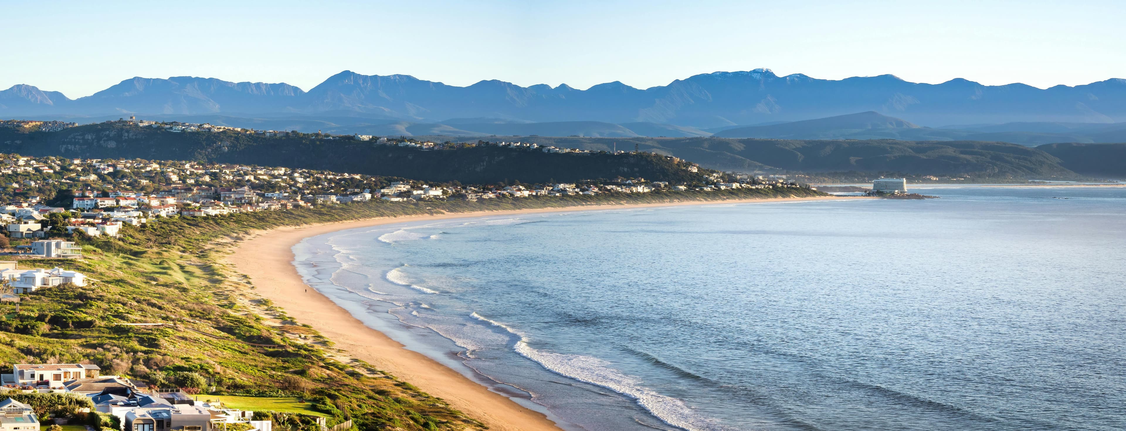 A view of the Garden Route's rugged beach with a bright blue ocean.